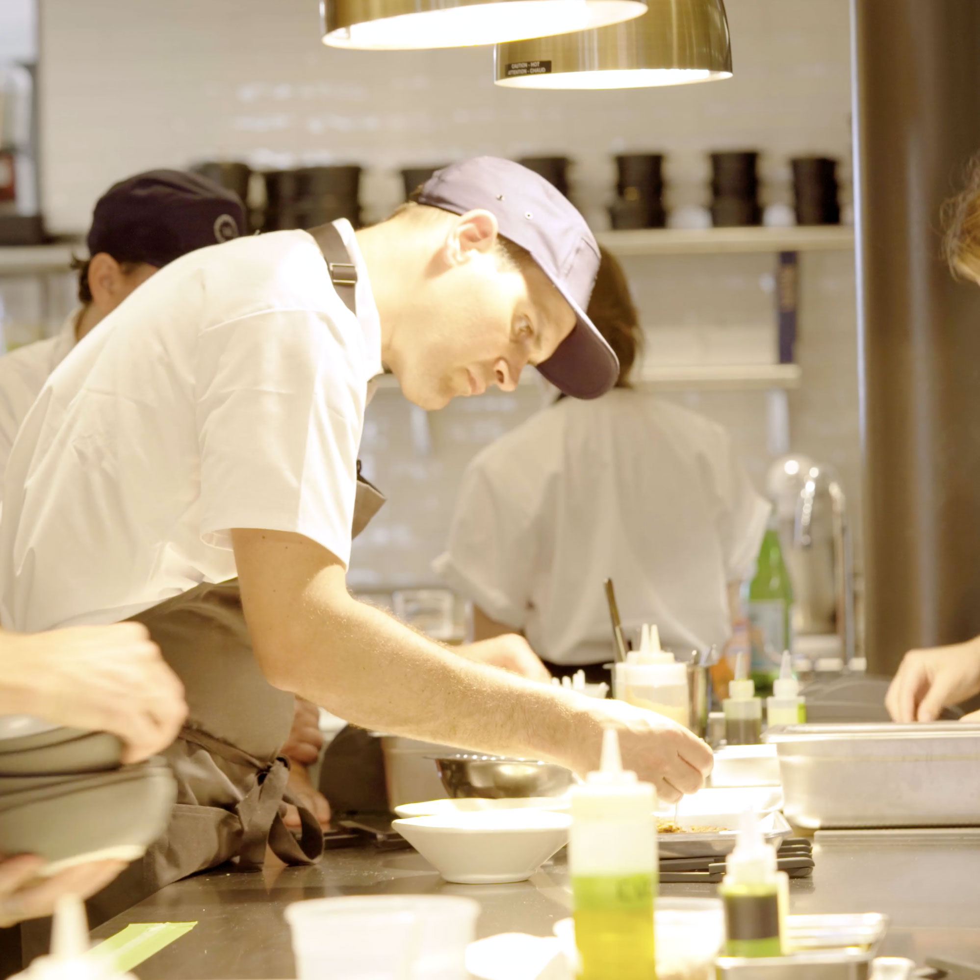 Twelve Square Photo of Colin Wyatt, the executive chef of Twelve Restaurant in Maine, preparing food for guests.