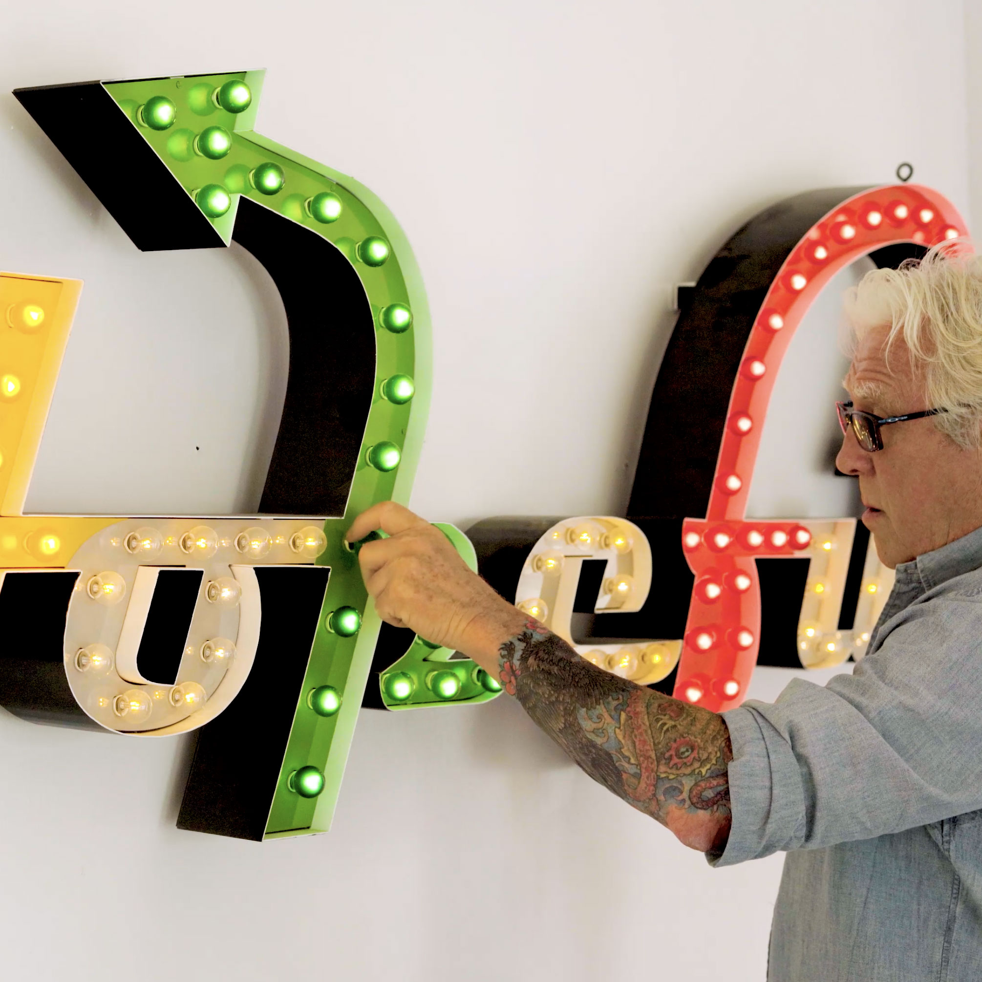 Charlie Square cPort Credit Union business member and Maine artist Charlie Hewitt from The Hopeful Project changing a light bulb on his iconic design - Hopeful
