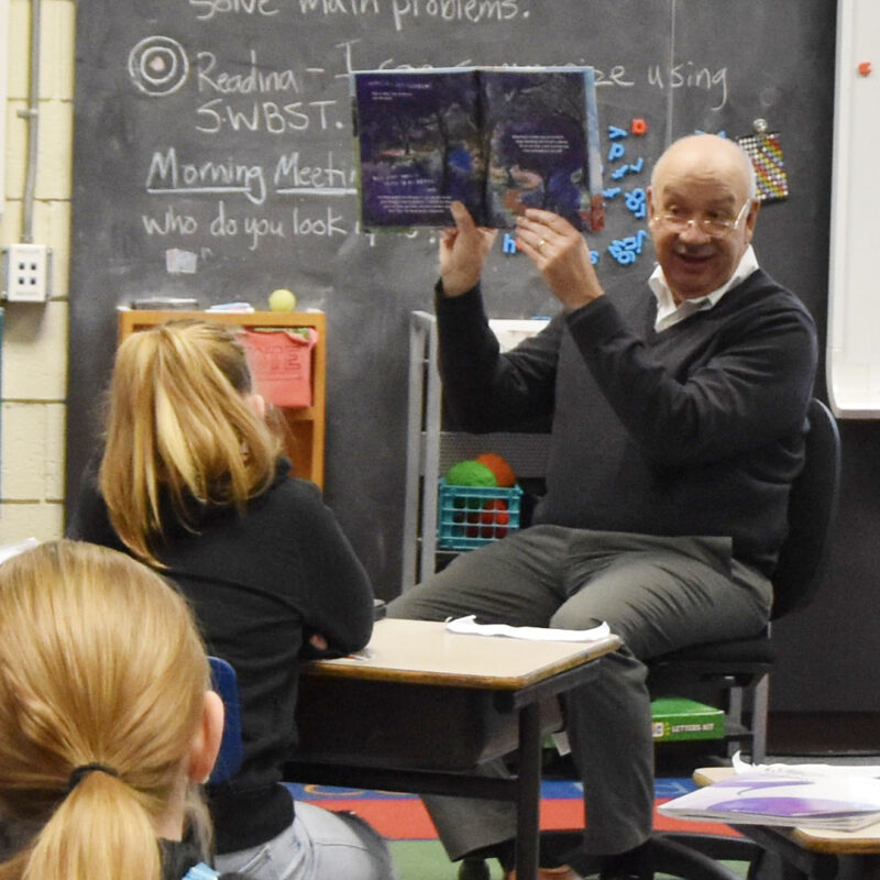Gene Ardito, the President & CEO of cPort Credit Union in Maine reading a book to a class of students at Talbot Community School in Portland, Maine.