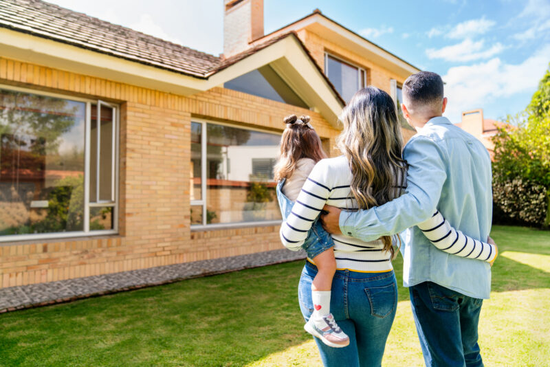 Loving Family Outdoors Looking At Their New House