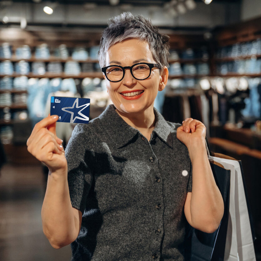 Business Wiman holding up aDebit Card