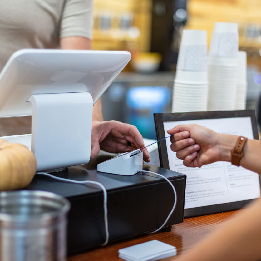 In Western Colorado Shopping using credit card women young millennial hand inserting card into chip reader indoors at a coffee shop (Shot with Canon 5DS 50.6mp photos professionally retouched - Lightroom / Photoshop - original size 5792 x 8688 downsampled as needed for clarity and select focus used for dramatic effect)