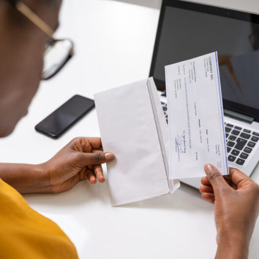 American African Holding Paycheck Or Payroll Check